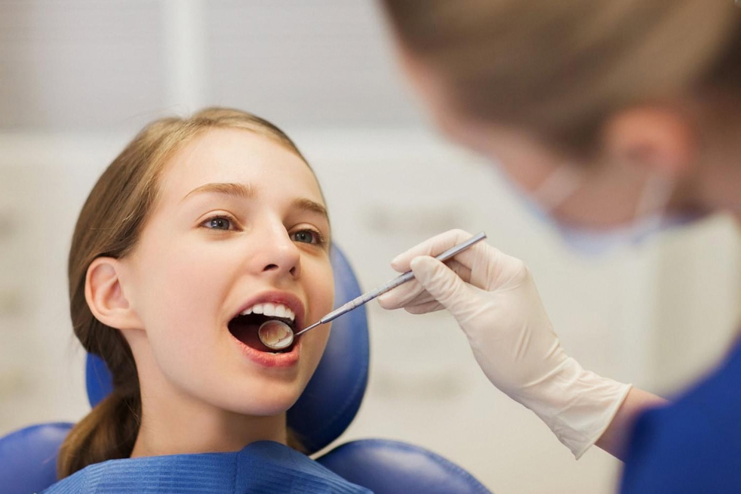 Child having her teeth examined during a routine cavity prevention checkup
